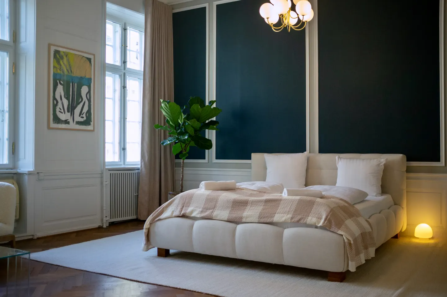 Finished Copenhagen bedroom with dark wall panelling, soft curtains and warm lighting