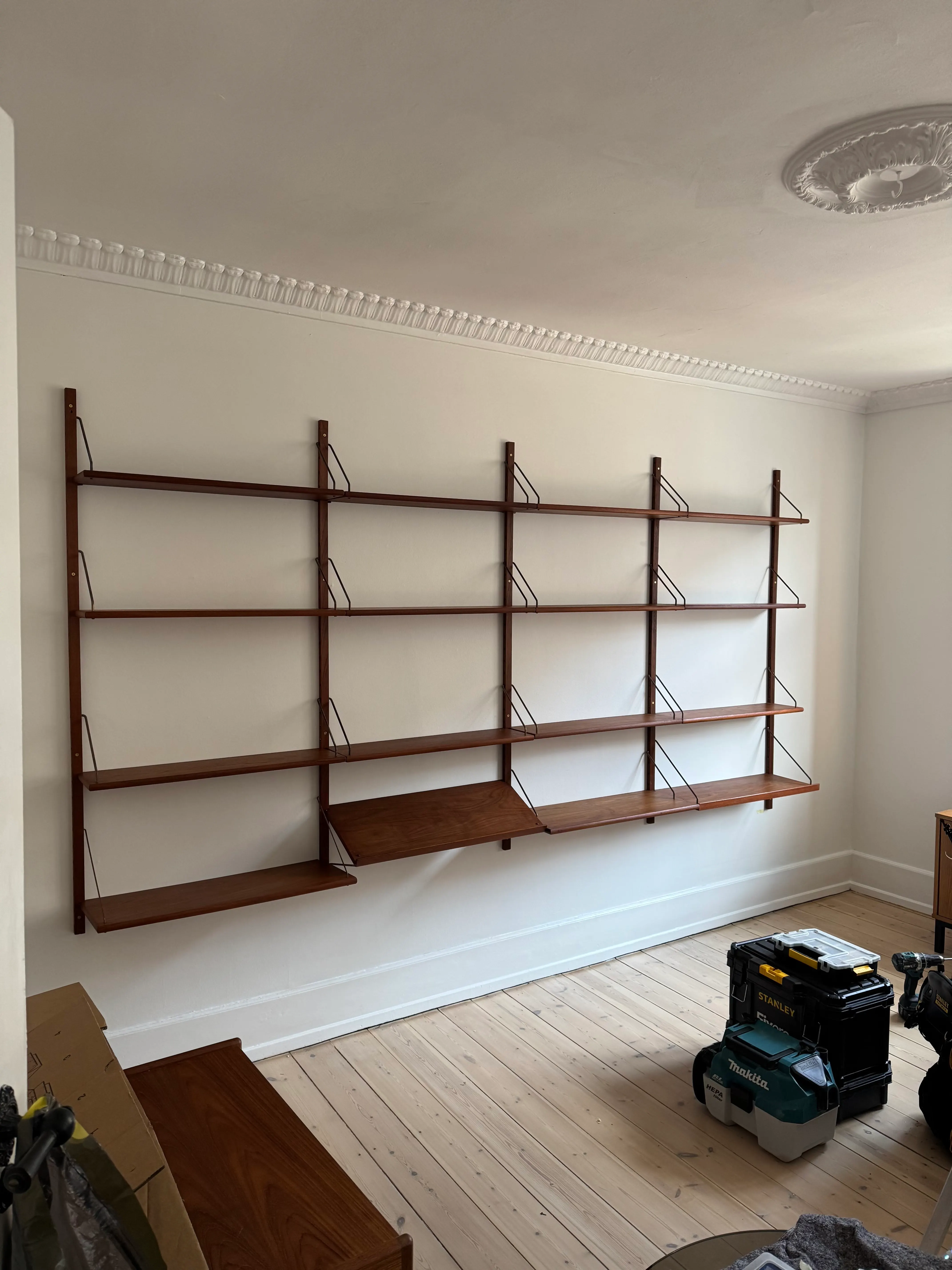 Completed four-section Cadovius Royal wall shelving system in a Frederiksberg living room
