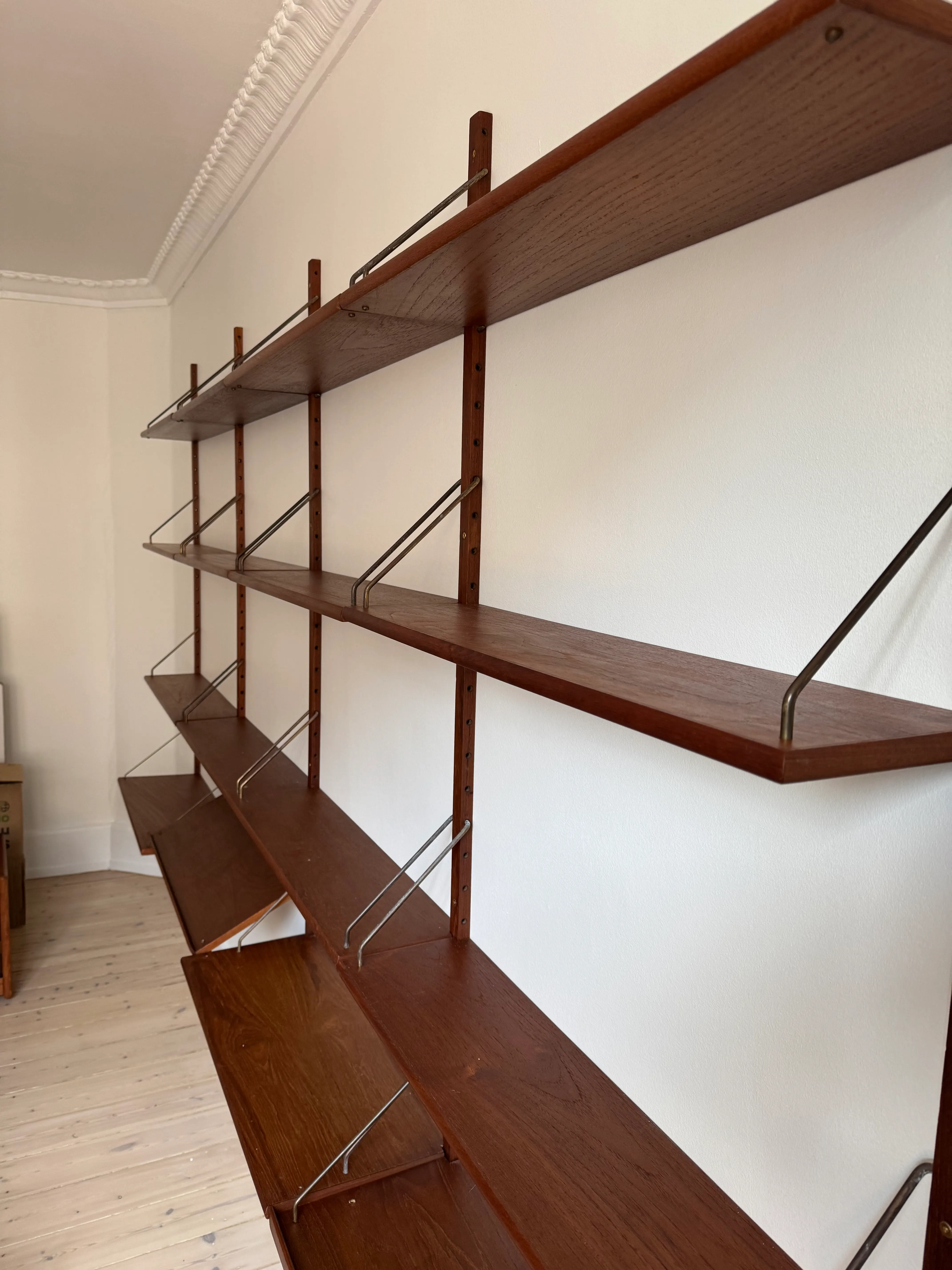 Close-up of assembled Cadovius Royal timber shelves and metal supports