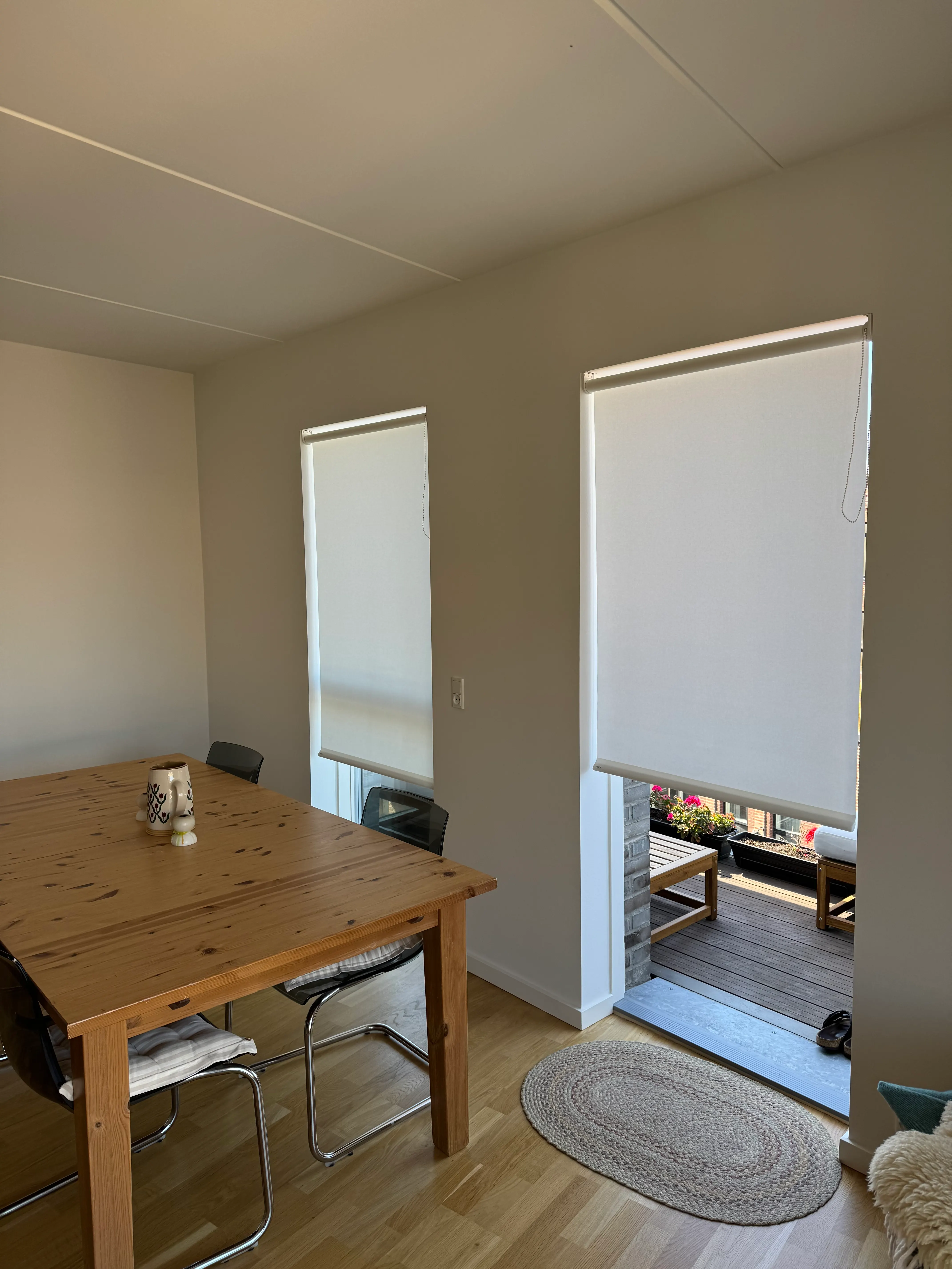 Two precisely positioned roller blinds installed in adjacent openings in a Valby apartment